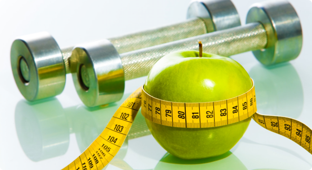 a green apple with tape measure